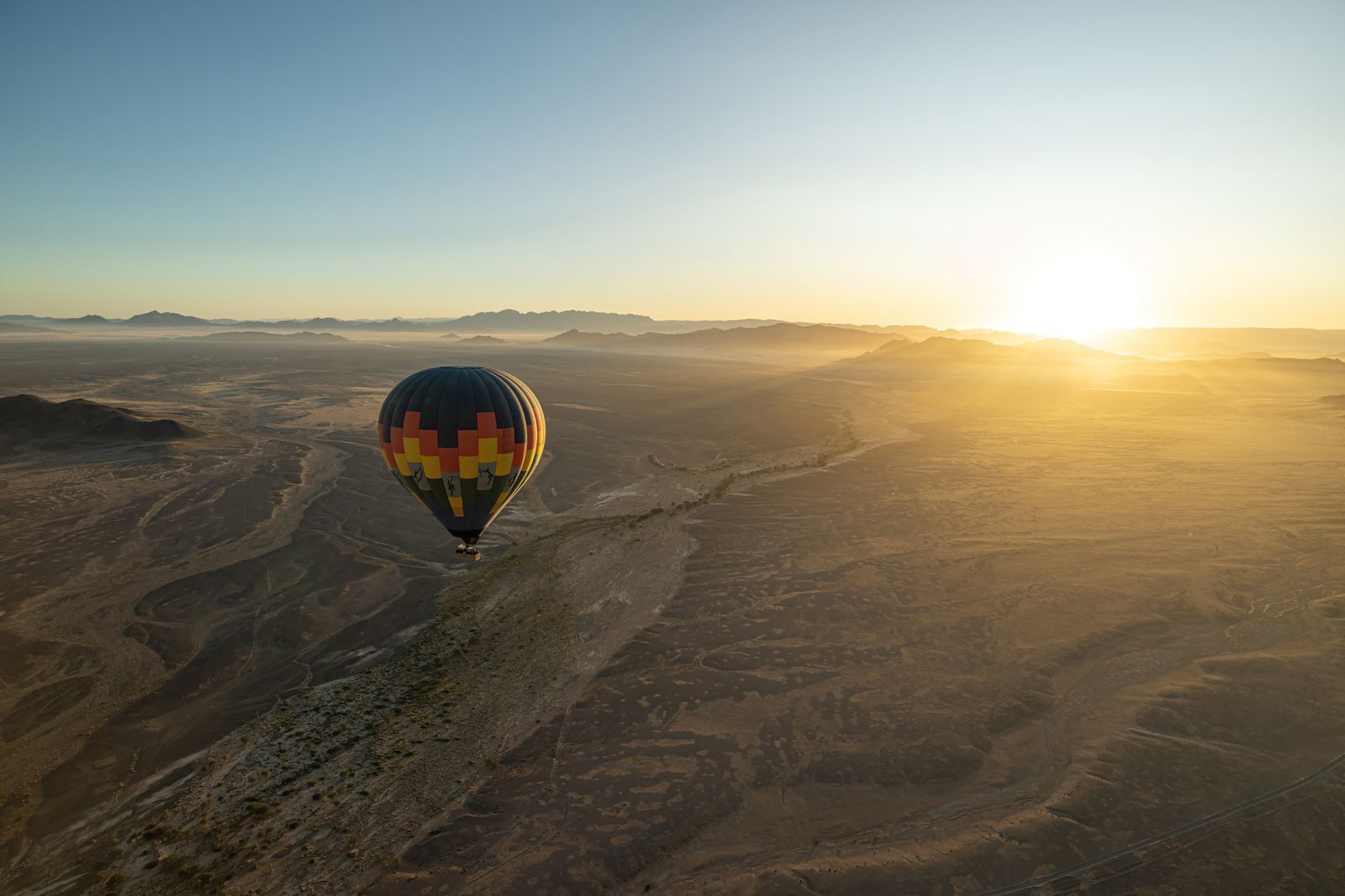 끝없이 펼쳐진 붉은 사막 위로 떠오르는 황금빛 일출의 경이로운 순간.