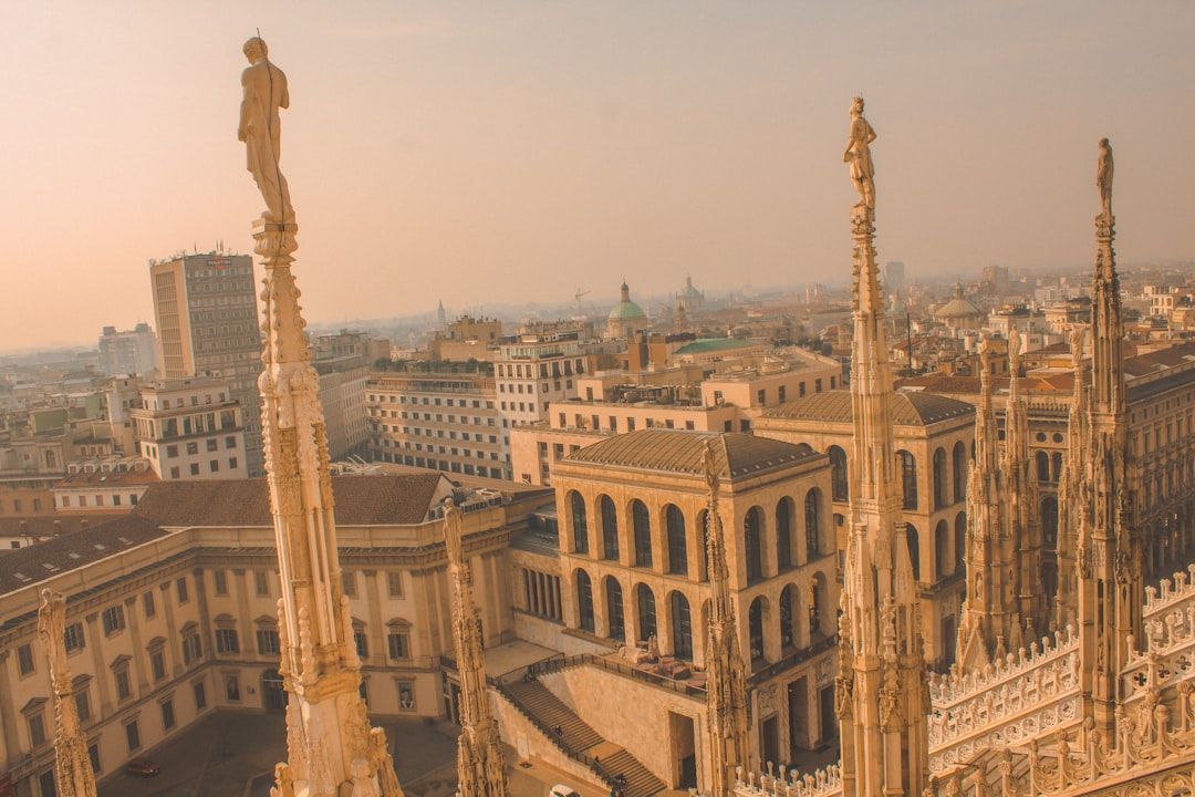 황금빛 노을에 물든 밀라노 두오모의 섬세한 조각과 도시의 전경