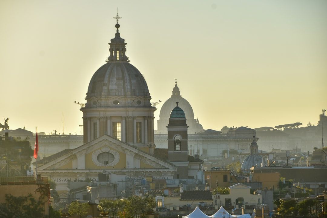 Domes of old buildings against a hazy sky.